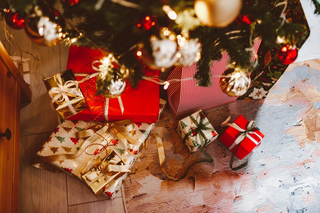 A wrapped gift beside a board game box under warm holiday lights