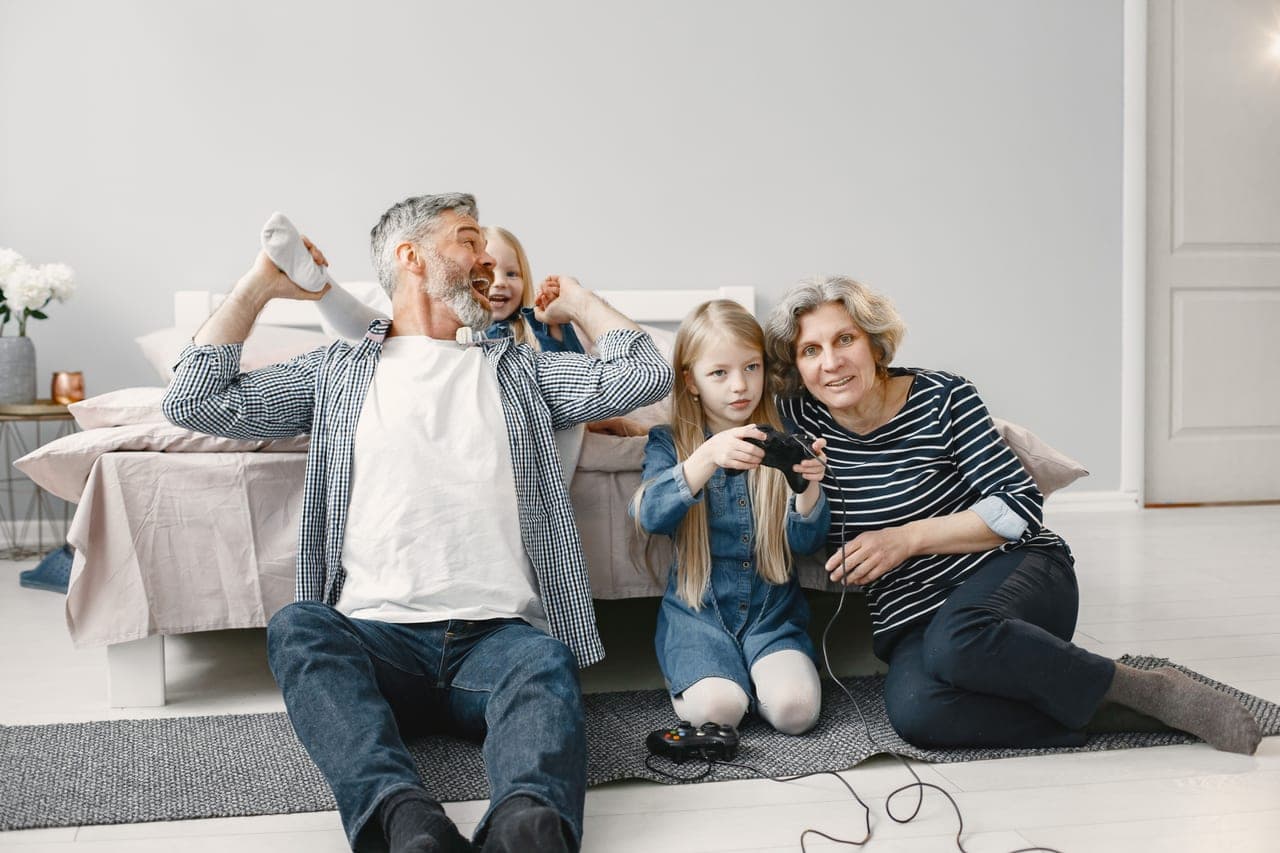 Parents and two children playing a board game together on the floor